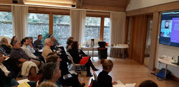 Group of delegates viewing an online speaker at the conference evetn.
